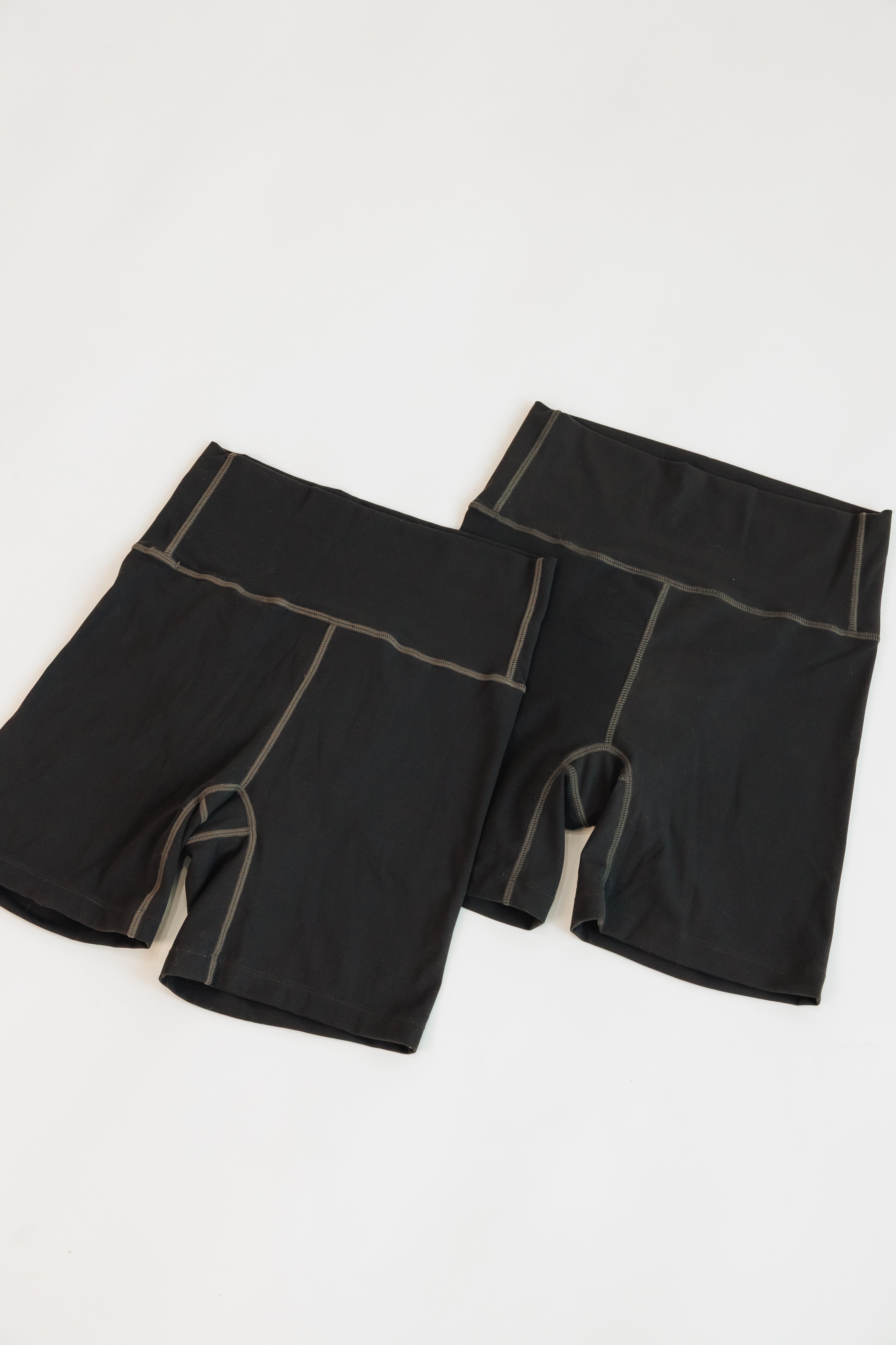 Two black Embodie Renew Shorts shown together, featuring the high-rise waistband and supportive fit.