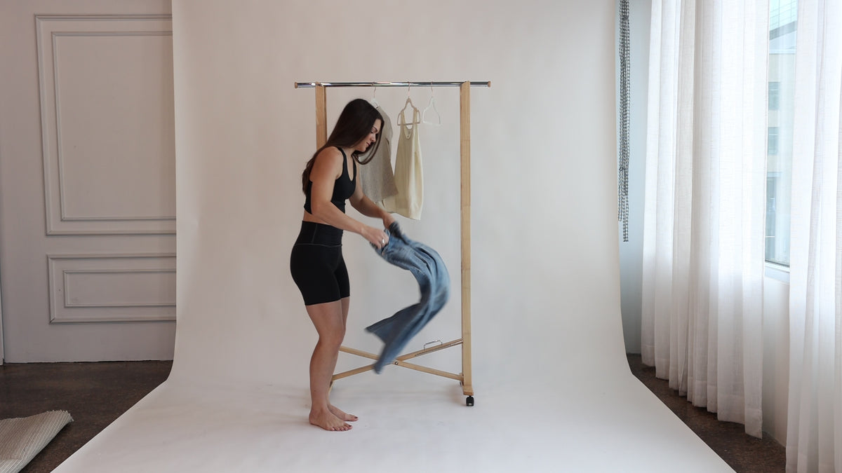 Woman pulling jeans on over the Embodie Renew Short to show its smooth, everyday fit.